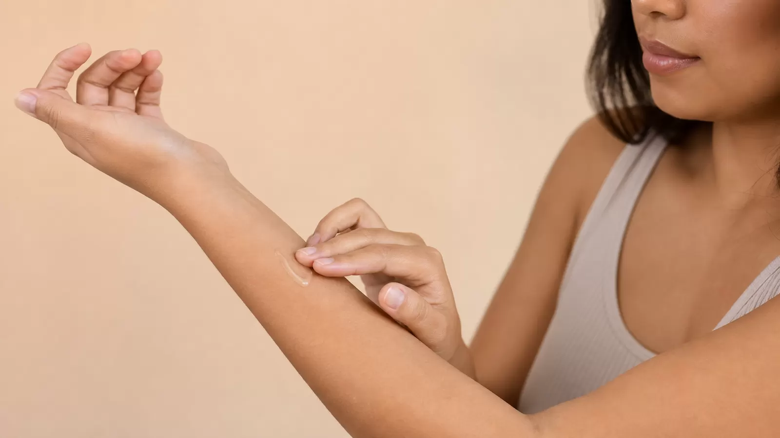 Person applying a small amount of skincare product to the inner forearm for a patch test